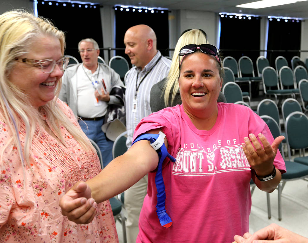 Las Vegas Academy photography visual arts instructor Dawn Anderson, left, and physical education teacher Amy Steinmetz learn how to apply a tourniquet during University Medical Center "Stop t ...