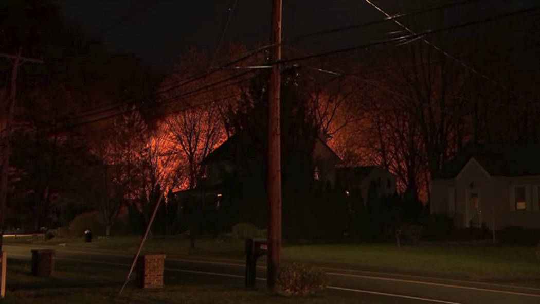 This image provided by WFSB-TV shows a fire behind a house in North Haven, Conn., Wednesday, May 2, 2018. A barn behind a house in Connecticut exploded Wednesday night while police and a SWAT team ...