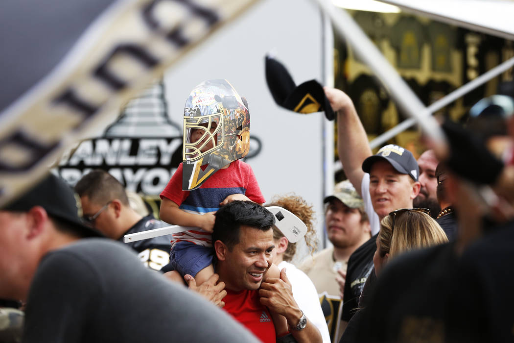 Robert Casillas hoists his 3-year-old son Robert Jr. during a Vegas Golden Knights watch party for game six of the Stanley Cup playoffs outside on Toshiba Plaza in Las Vegas on Sunday, May 6, 2018 ...