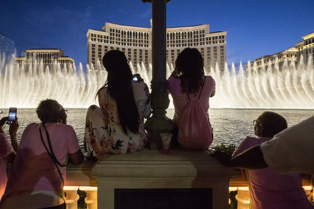 Members of Alpha Kappa Alpha Sorority gather at the Bellagio Fountains for their leadership conference's opening ceremony on Thursday, July 13, 2017, in Las Vegas. The fountains were illuminated g ...