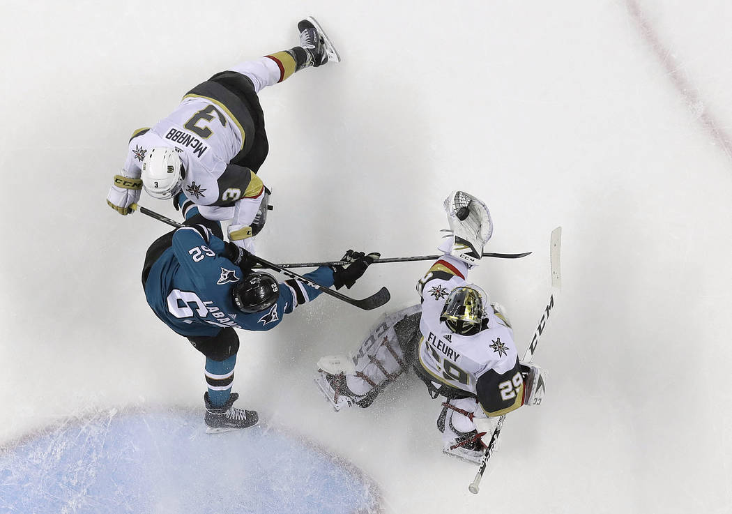 Vegas Golden Knights goaltender Marc-Andre Fleury, right, gloves the puck next to San Jose Sharks' Kevin Labanc, center, and Golden Knights defenseman Brayden McNabb (3) during the second period o ...
