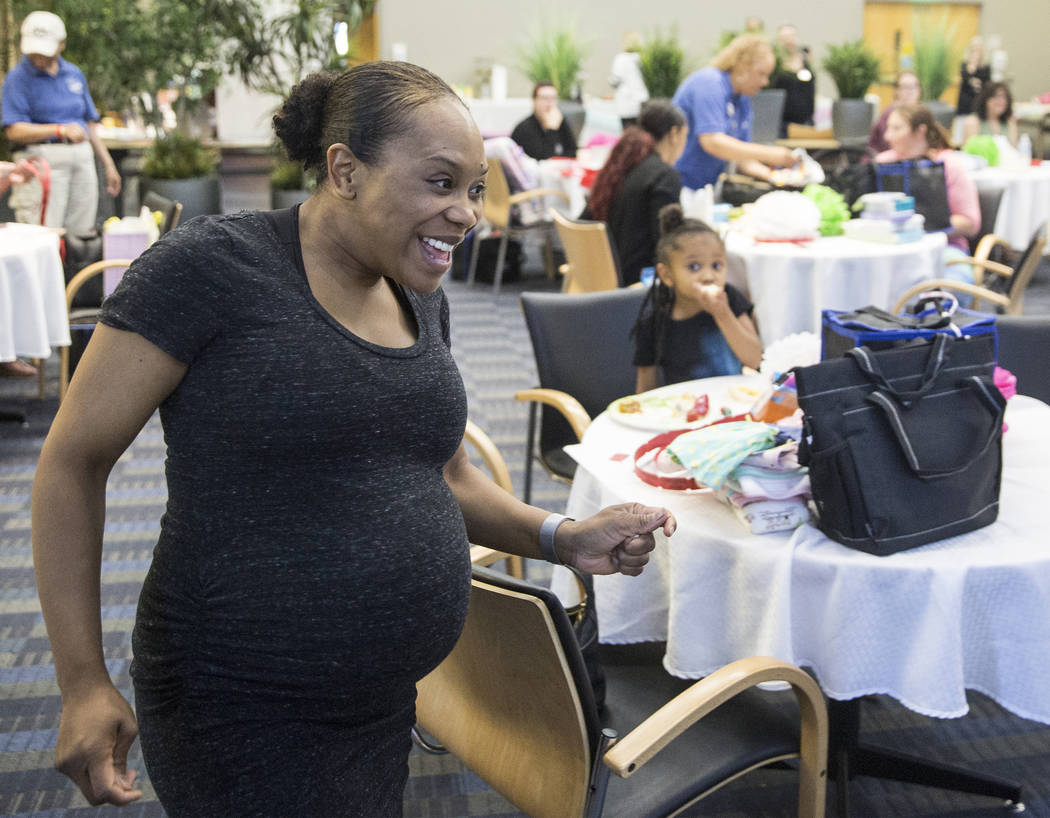 Yasmeen Donahue, left, walks to the podium after her raffle number was called during a baby shower sponsored by the Veteran's Affairs Southern Nevada Healthcare System in partnership with the Eliz ...