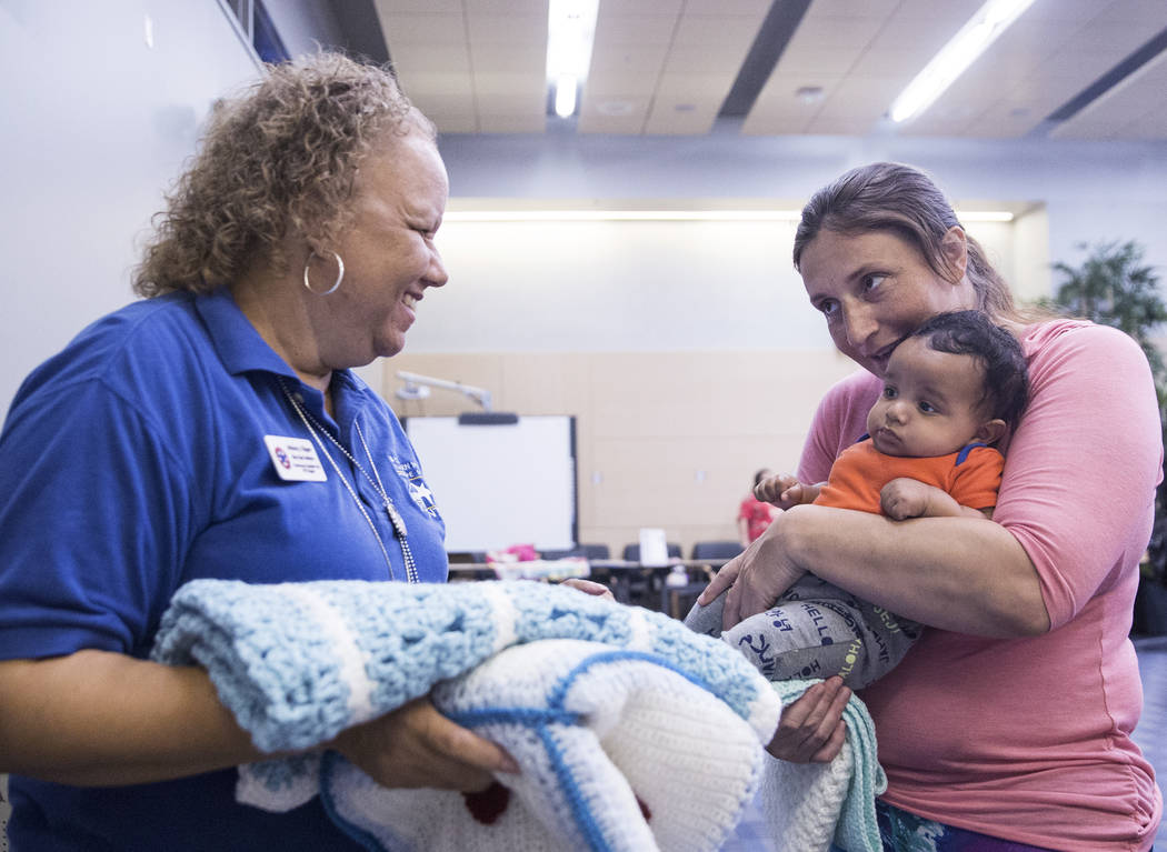 Melissa Clipper, left, of Blue Star Mothers, hands a baby blanket to Jennifer Louise and son Achilles during a baby shower sponsored by the Veteran's Affairs Southern Nevada Healthcare System in p ...