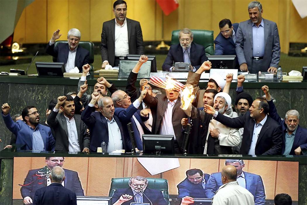 Iranian lawmakers burn two pieces of papers representing the U.S. flag and the nuclear deal as they chant slogans against the U.S. at the parliament in Tehran, Iran, Wednesday, May 9, 2018. (AP Photo)