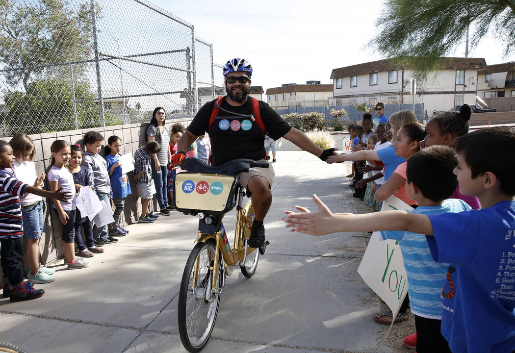 Students at Robert L. Taylor Elementary School greet Matthew Chavez as he delivers books to their school during the eighth annual “Ride for Reading” event on Friday, May 11, 2018, in Henderson ...