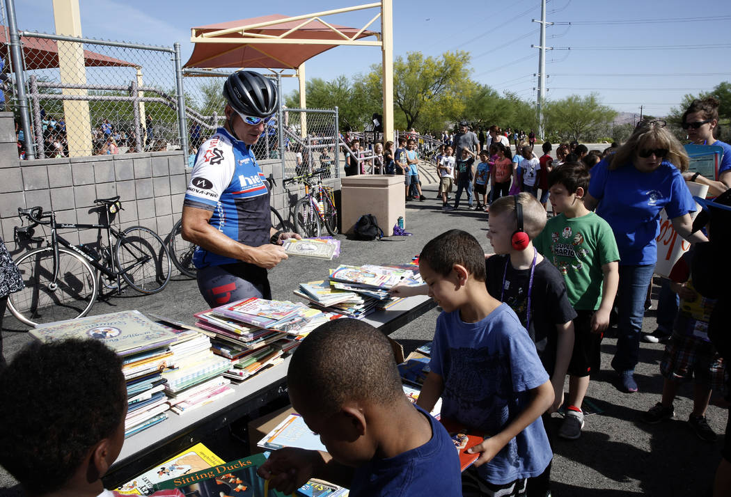 Mark Greenberg, left, watches as Robert L. Taylor Elementary School students select their books during the eighth annual “Ride for Reading” event on Friday, May 11, 2018, in Henderso ...