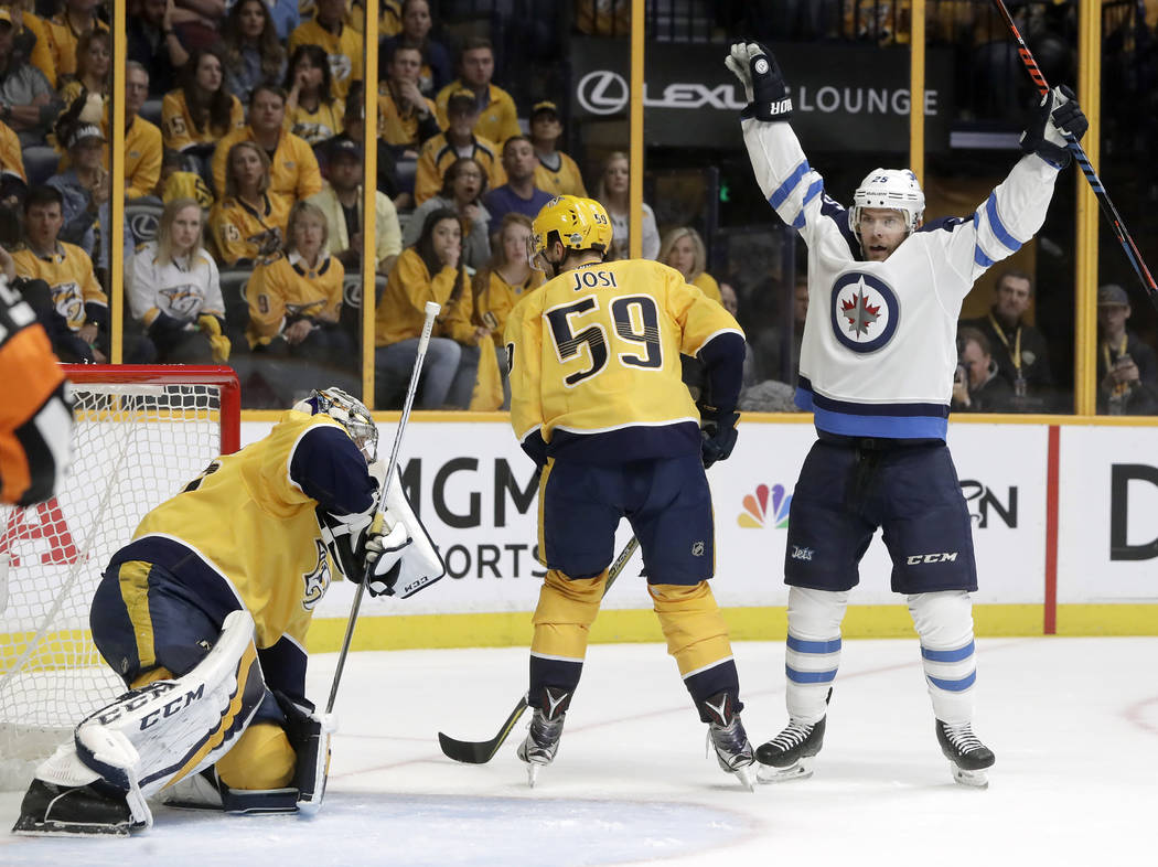 Winnipeg Jets center Paul Stastny, right, celebrates after teammate Tyler Myers, not shown, scored a goal against Nashville Predators goalie Pekka Rinne, left, of Finland, during the first period ...