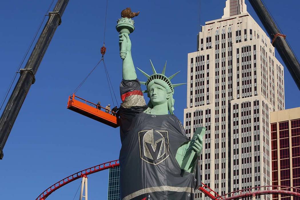 Workers install a Vegas Golden Knights jersey on the Statue of Liberty at New York New York on Friday, April 13, 2018, in Las Vegas. Bizuayehu Tesfaye/Las Vegas Review-Journal @bizutesfaye