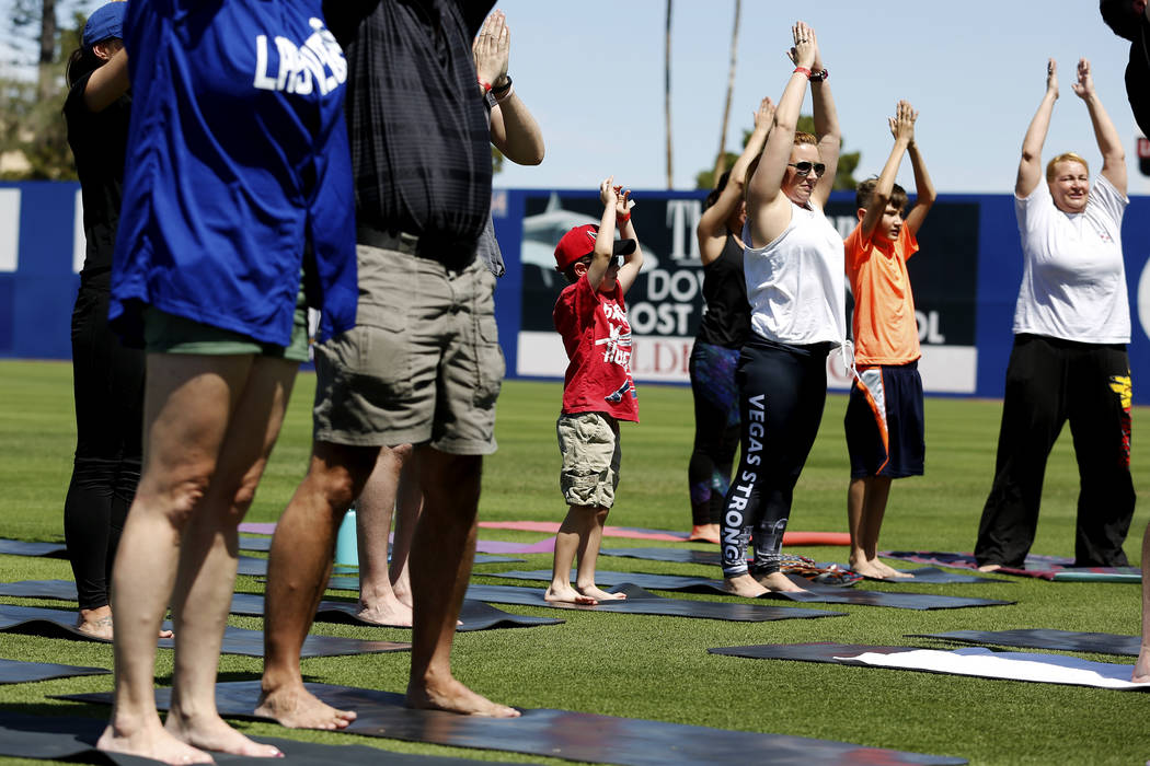 Attendees participate in a Yoga on the Field event at Cashman Field in Las Vegas on Sunday, May 13, 2018. Andrea Cornejo Las Vegas Review-Journal @dreacornejo