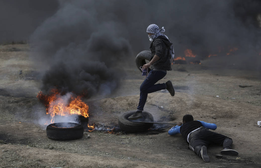 Palestinian protesters burn tires during a protest on the Gaza Strip's border with Israel, Monday, May 14, 2018. Thousands of Palestinians are protesting near Gaza's border with Israel, as Israel ...