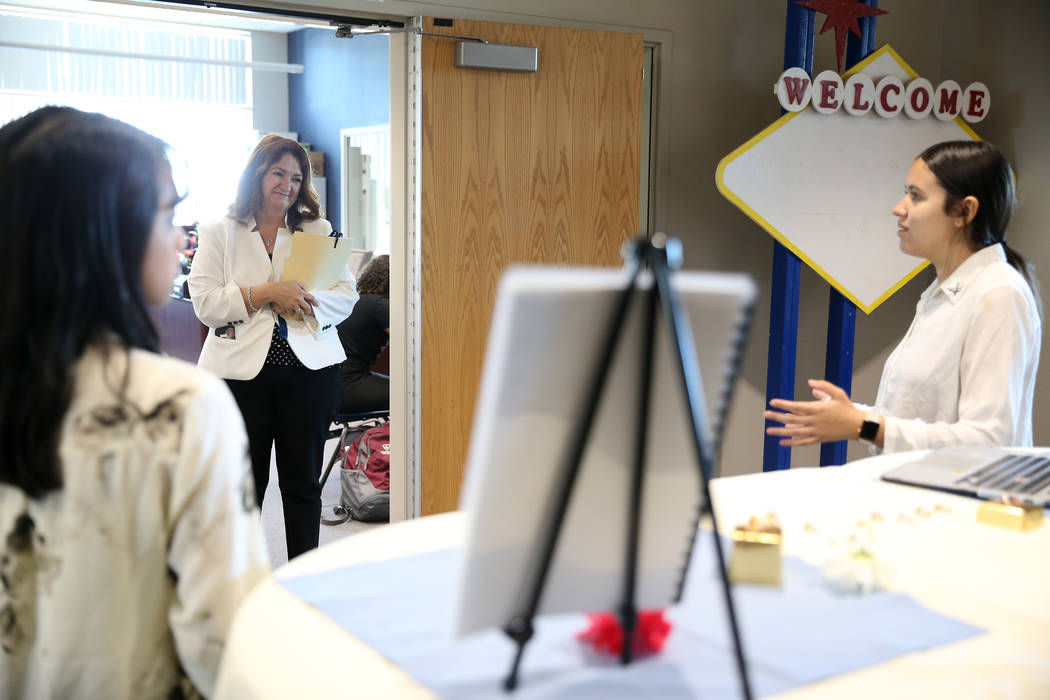 East Career and Technical Academy principal Darlin Delgado, center, looks on during a presentation by Aurora Osuna, 16, right, and Kirsten Nicholas, marketing and hospitality students, during a pr ...