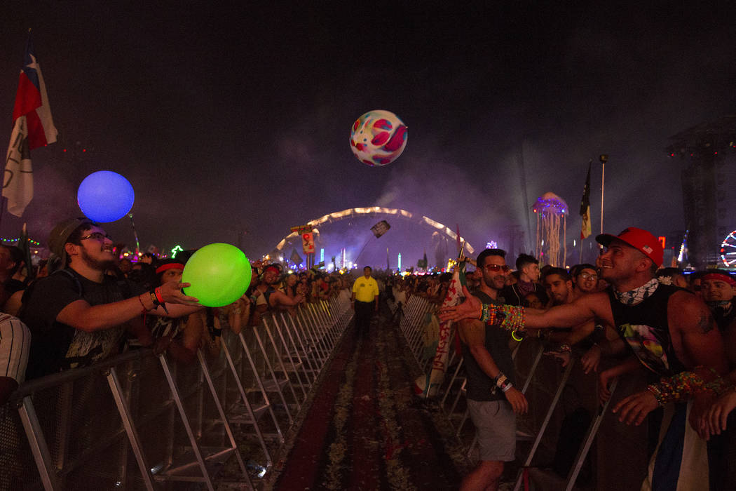 Juan Ignacio Ortiz Frutos, left, from Mexico and Leonard Romero Rodriguez, right, from Cuba exchange balloons during Tiesto's set at Kinetic Field on the second night of Electric Daisy Carnival at ...