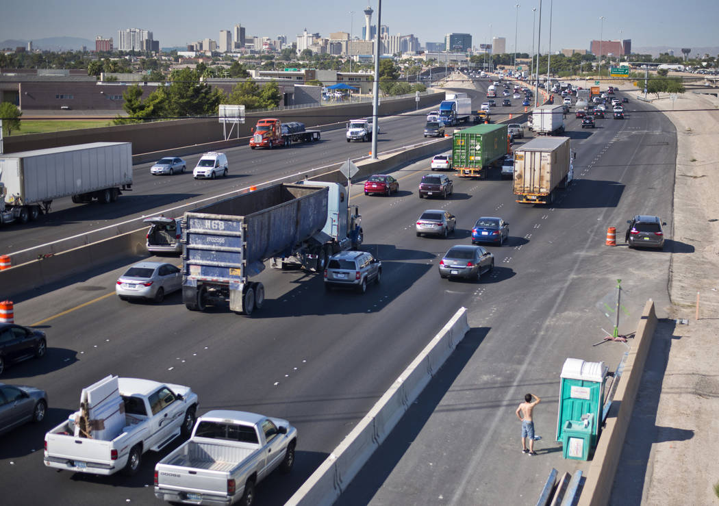 A motorist waits to use a construction port-a-potty in congested traffic on southbound Interstate 15 near downtown Las Vegas as Electric Daisy Carnival festival-goers mingle with the morning commu ...