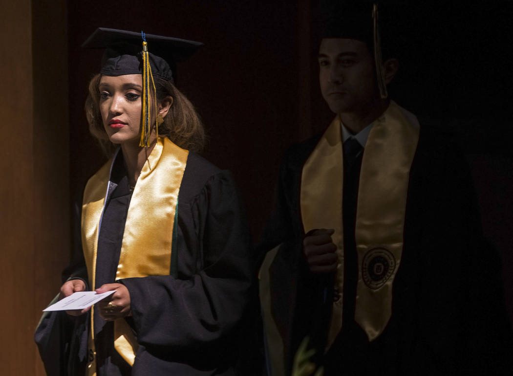 Niyat Teweldebrhan, left, a 28-year-old Eritrean refugee who survived war in her home country, waits on stage to receive her Masters of Science in medical health sciences from the College of Osteo ...