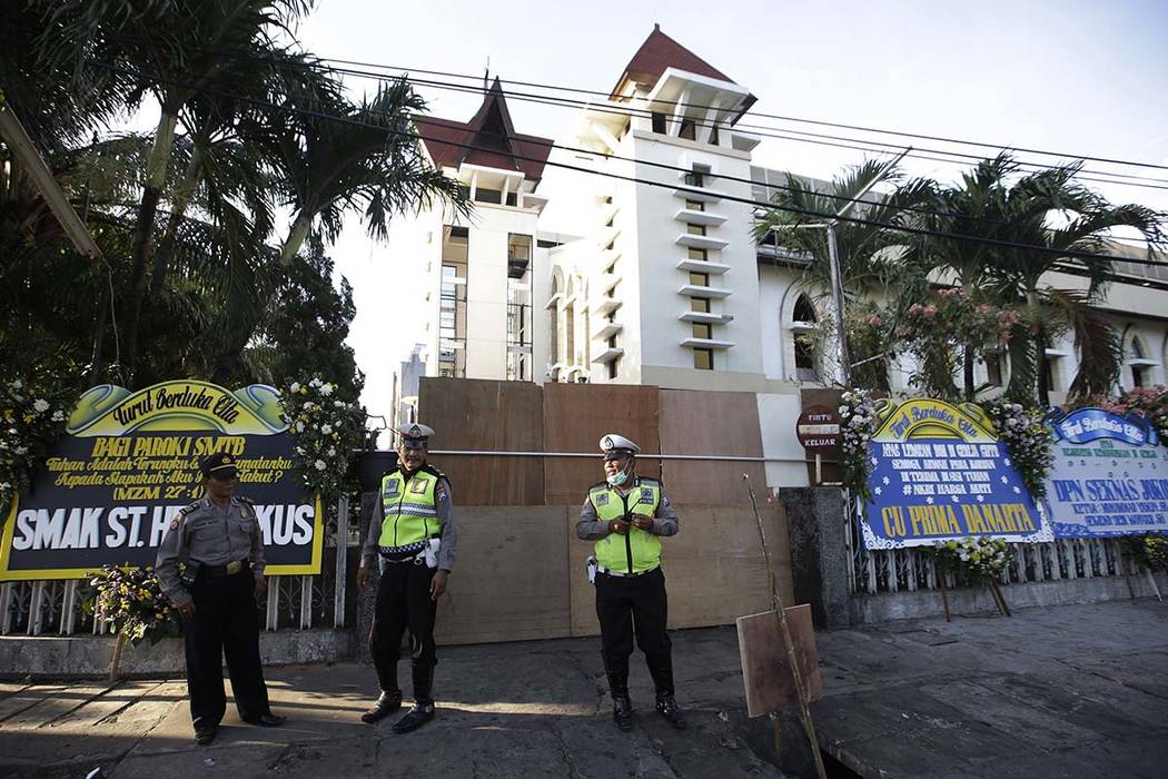 Police officers stand guard outside one of the churches attacked on Sunday, in Surabaya, East Java, Indonesia, Monday, May 14, 2018. The flurry of bombings raised concerns that previously beaten-d ...