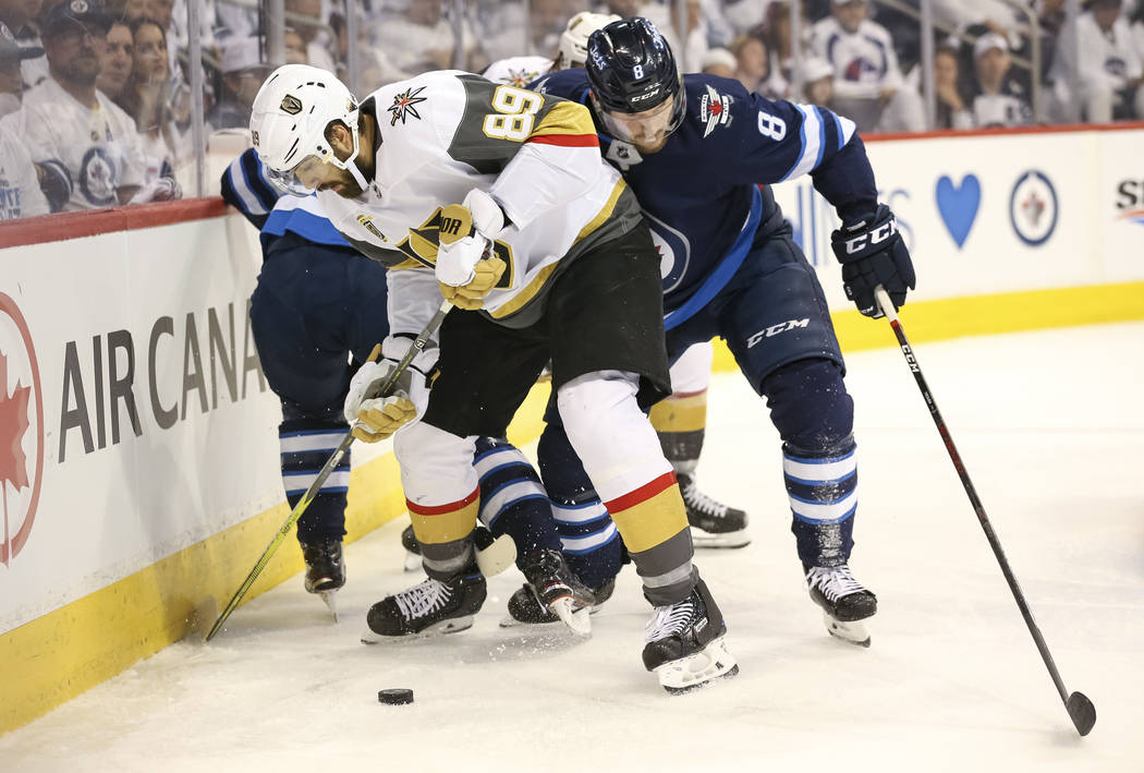 Vegas Golden Knights right wing Alex Tuch (89) keeps the puck away from Winnipeg Jets defenseman Jacob Trouba (8) during the second period in Game 2 of an NHL hockey third round playoff series at ...