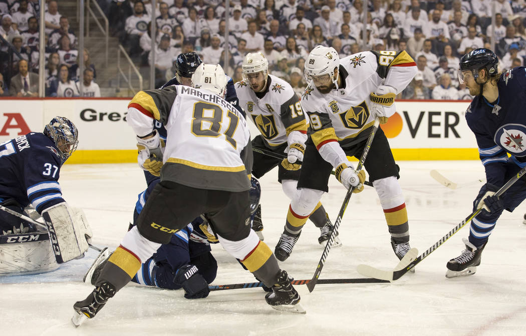 Vegas Golden Knights center Jonathan Marchessault (81), Reilly Smith (19) and Alex Tuch (89) look for the rebound against the Winnipeg Jets during the second period in Game 2 of an NHL hockey thir ...