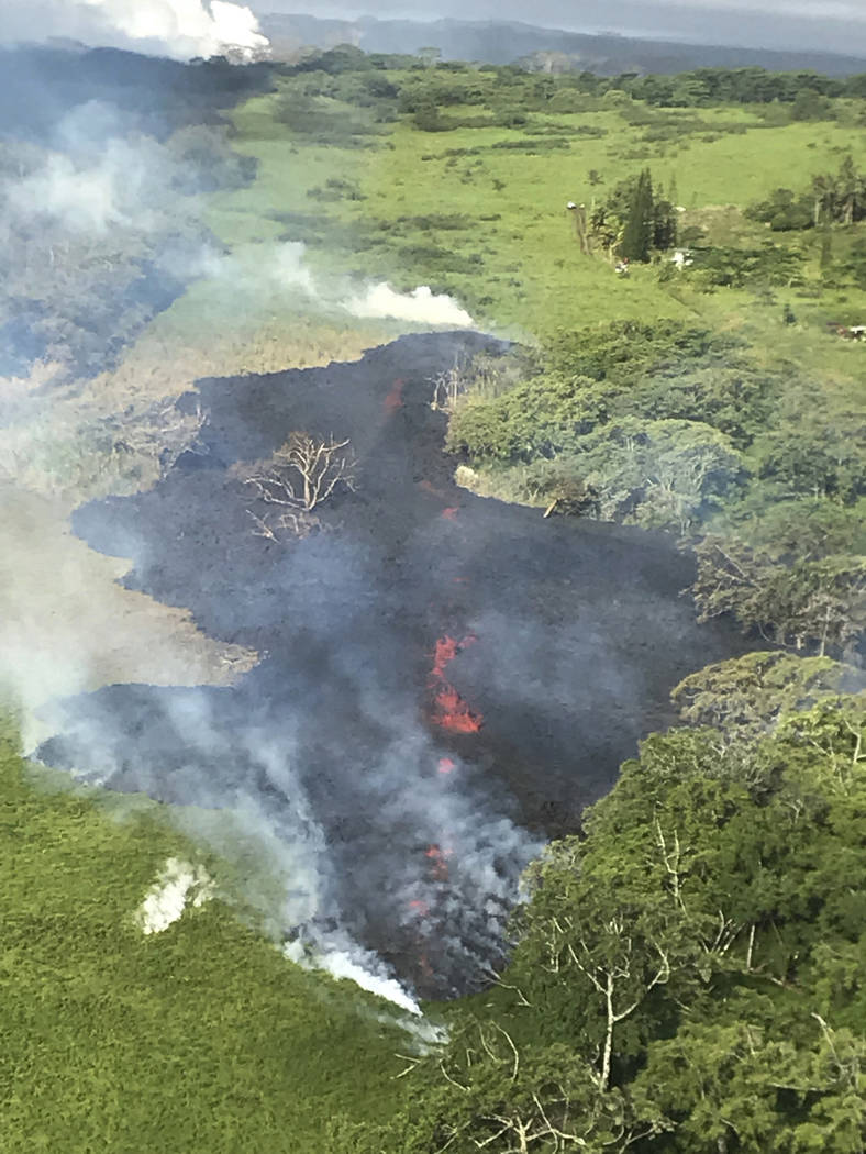 In this May 13, 2018 photo released by the U.S. Geological Survey, gases rise from a fissure near Pahoa, Hawaii. The new fissure in Hawaii's Puna District sent gases and lava exploding into the ai ...
