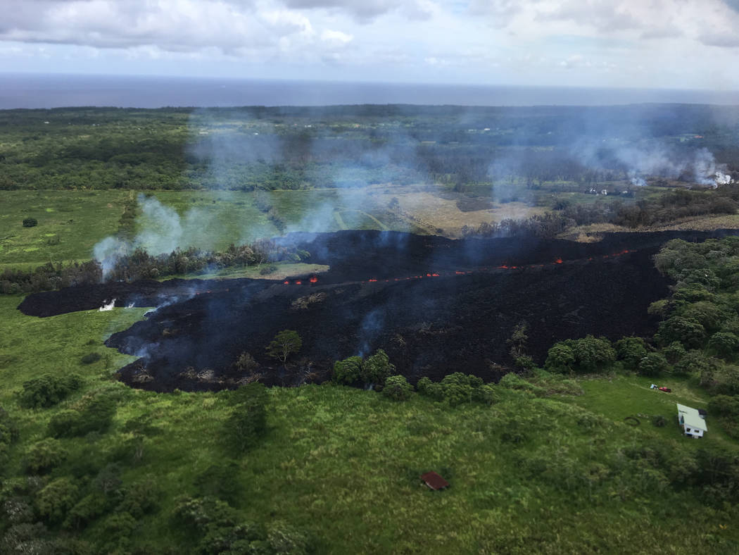 In this May 13, 2018 photo released by the U.S. Geological Survey, gases rise from a fissure near Pahoa, Hawaii. The new fissure in Hawaii's Puna District sent gases and lava exploding into the ai ...