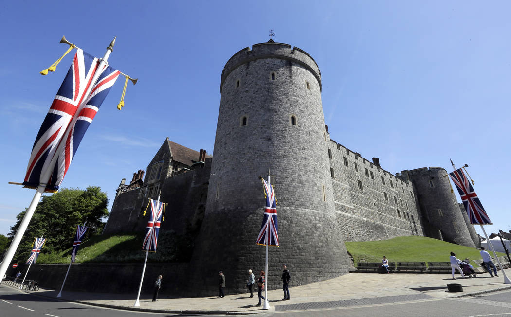 Flags fly in front of the castle in Windsor, England, Monday, May 14, 2018. Preparations are being made in the town ahead of the wedding of Britain's Prince Harry and Meghan Markle that will take ...