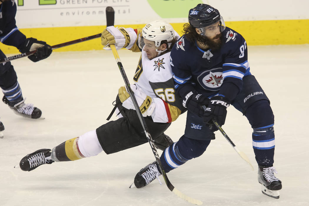 Vegas Golden Knights left wing Erik Haula (56) falls to ice after colliding with Winnipeg Jets center Mathieu Perreault (85) during the third period in Game 2 of an NHL hockey third round playoff ...