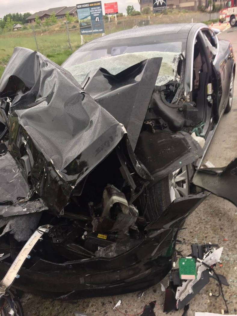 In this Friday, May 11, 2018, photo released by the South Jordan Police Department shows a traffic collision involving a Tesla Model S sedan with a Fire Department mechanic truck stopped at a red ...
