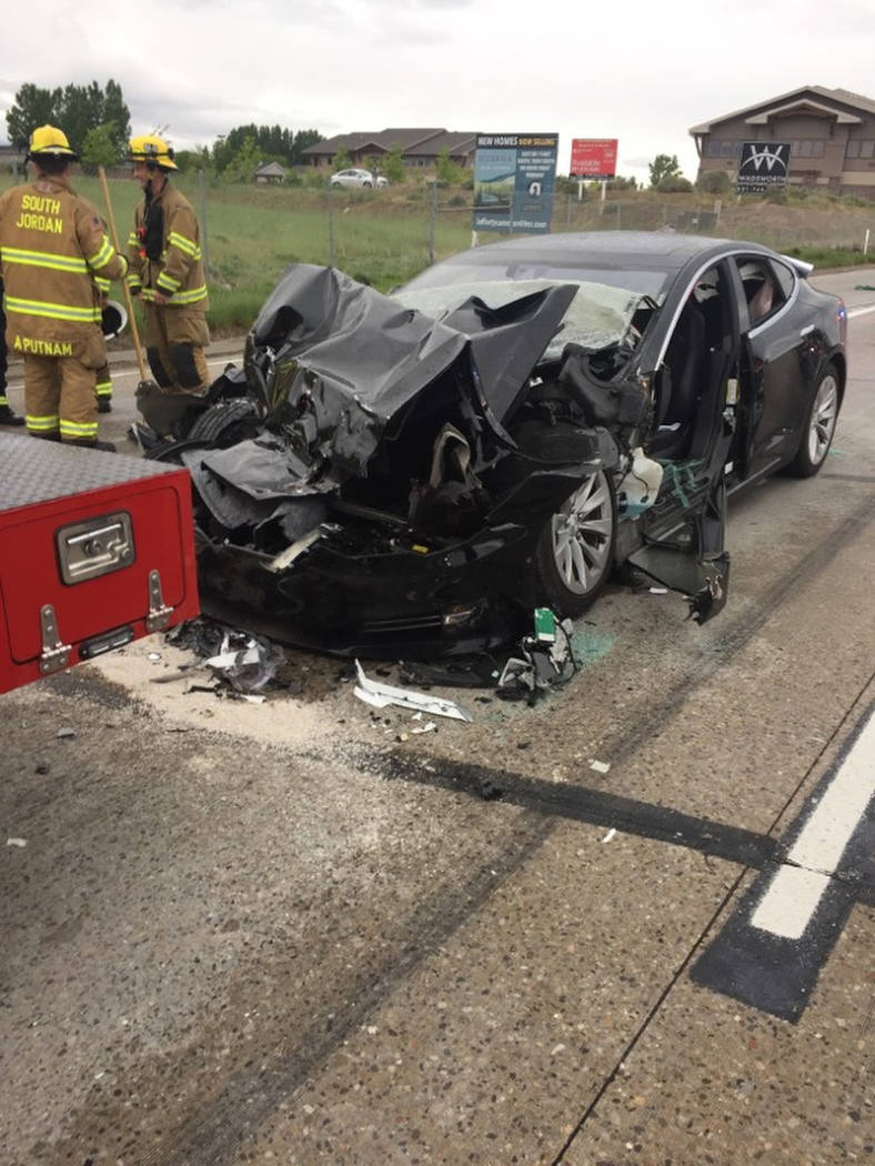 In this Friday, May 11, 2018, photo released by the South Jordan Police Department shows a traffic collision involving a Tesla Model S sedan with a Fire Department mechanic truck stopped at a red ...