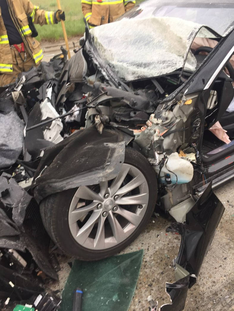 In this Friday, May 11, 2018, photo released by the South Jordan Police Department shows a traffic collision involving a Tesla Model S sedan with a Fire Department mechanic truck stopped at a red ...