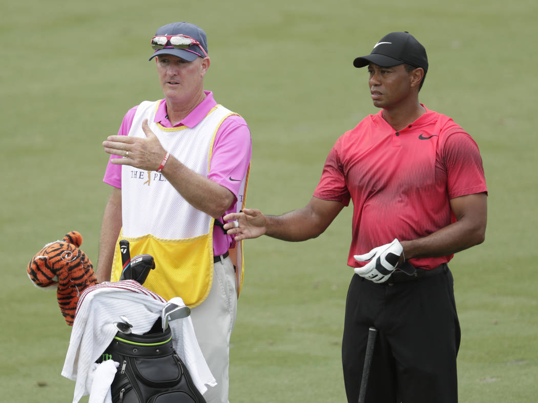 Tiger Woods and his caddie Joe Lacava, look down the third fairway, during the final round of The Players Championship golf tournament, Sunday, May 13, 2018, in Ponte Vedra Beach, Fla. (AP Photo/L ...