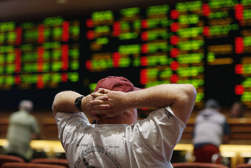 A man watches a baseball game in the sports book at the South Point hotel-casino, Monday, May 14, 2018, in Las Vegas. (AP Photo/John Locher)
