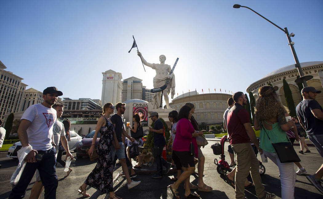 Pedestrians pass by a statue of Julius Caesar adorned with a Golden Knights flag and hockey stick outside of Caesars Palace in Las Vegas on Tuesday, May 15, 2018. Chase Stevens Las Vegas Review-Jo ...