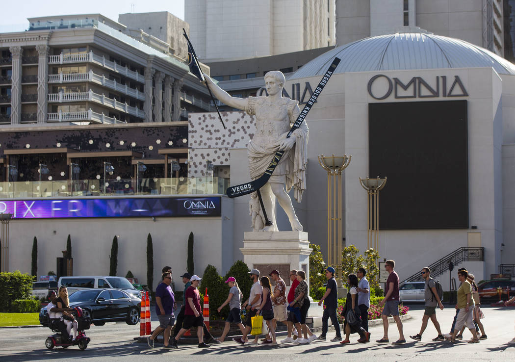 Pedestrians pass by a statue of Julius Caesar adorned with a Golden Knights flag and hockey stick outside of Caesars Palace in Las Vegas on Tuesday, May 15, 2018. Chase Stevens Las Vegas Review-Jo ...