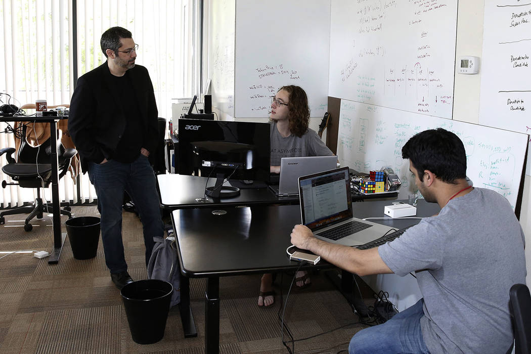 Rick Duggan, CEO at Concierge Software Design, chats with Triston Jones, senior software engineer, as Kandarp Dave, right, senior software engineer, works on his project at their Las Vegas office ...