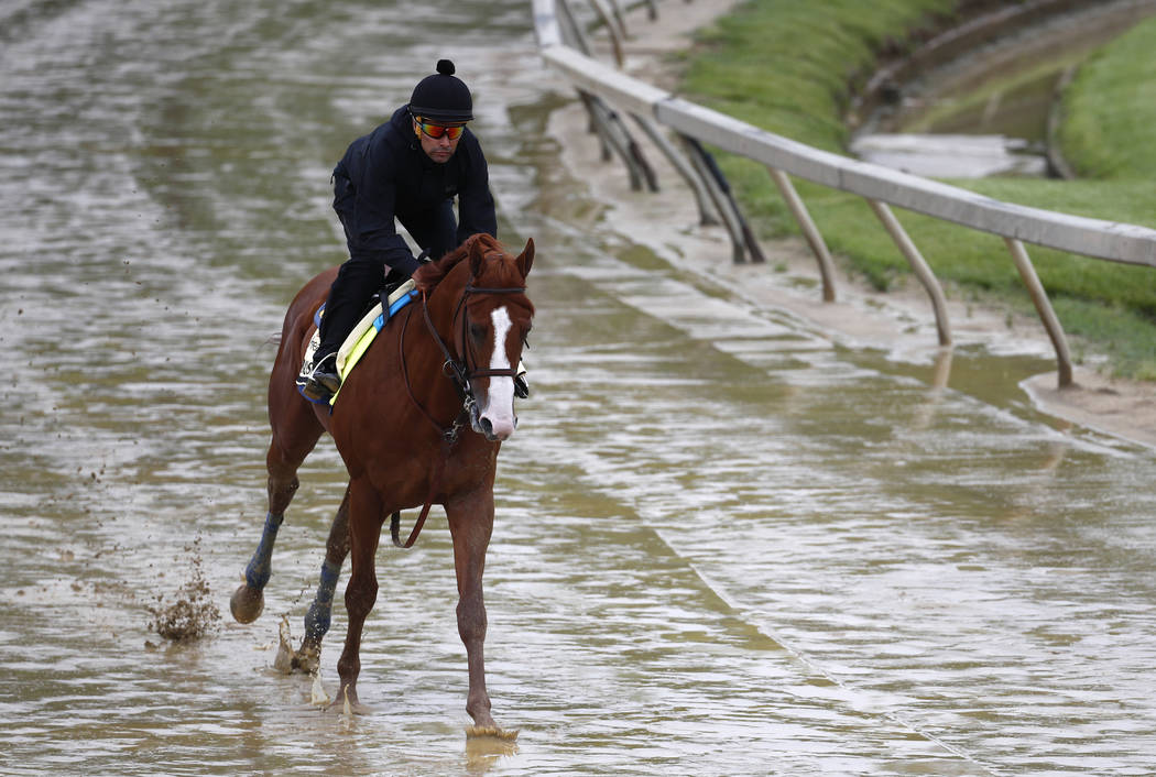 Kentucky Derby winner Justify, with exercise rider Humberto Gomez aboard, gallops around the track, Thursday, May 17, 2018, at Pimlico Race Course in Baltimore. The Preakness Stakes horse race is ...