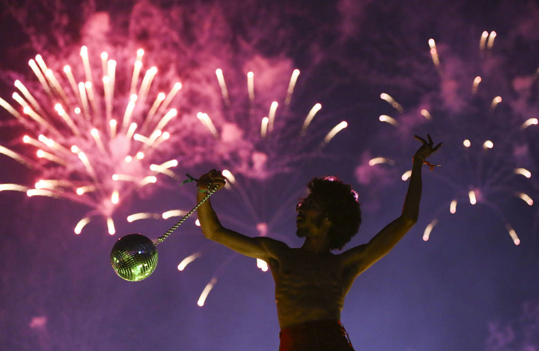 Deven Williams of the Kalliope dances on an art car as fireworks go off during the third day of the Electric Daisy Carnival at the Las Vegas Motor Speedway in Las Vegas during the early hours of M ...