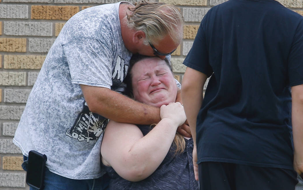 A man hugs a woman outside the Alamo Gym where parents wait to reunite with their children following a shooting at Santa Fe High School in Santa Fe, Texas, on Friday, May 18, 2018. (Michael Ciaglo ...