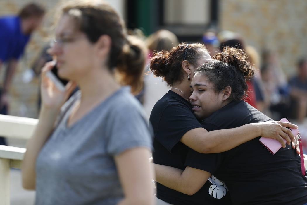 Santa Fe High School junior Guadalupe Sanchez, 16, cries in the arms of her mother, Elida Sanchez, after reuniting with her at a meeting point at a nearby Alamo Gym fitness center following a shoo ...