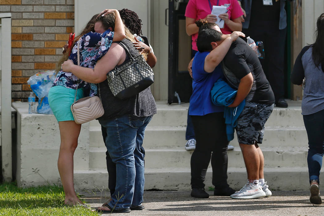 People embrace outside the Alamo Gym where students and parents wait to reunite following a shooting at Santa Fe High School Friday, May 18, 2018, in Santa Fe, Texas. ( Michael Ciaglo/Houston Chro ...