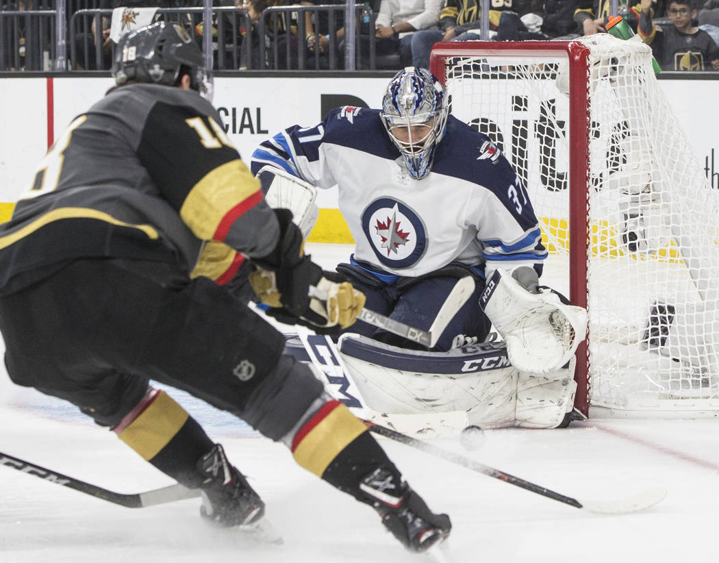 Jets goaltender Connor Hellebuyck (37) makes a save against Golden Knights left wing James Neal (18) in the third period during game four of Winnipeg's NHL Western Conference Finals matchup with ...