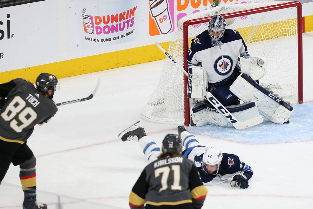 Winnipeg Jets goaltender Connor Hellebuyck (37) make a stop against Vegas Golden Knights right wing Alex Tuch (89) during the first period in Game 4 of the Western Conference Final at T-Mobile Are ...