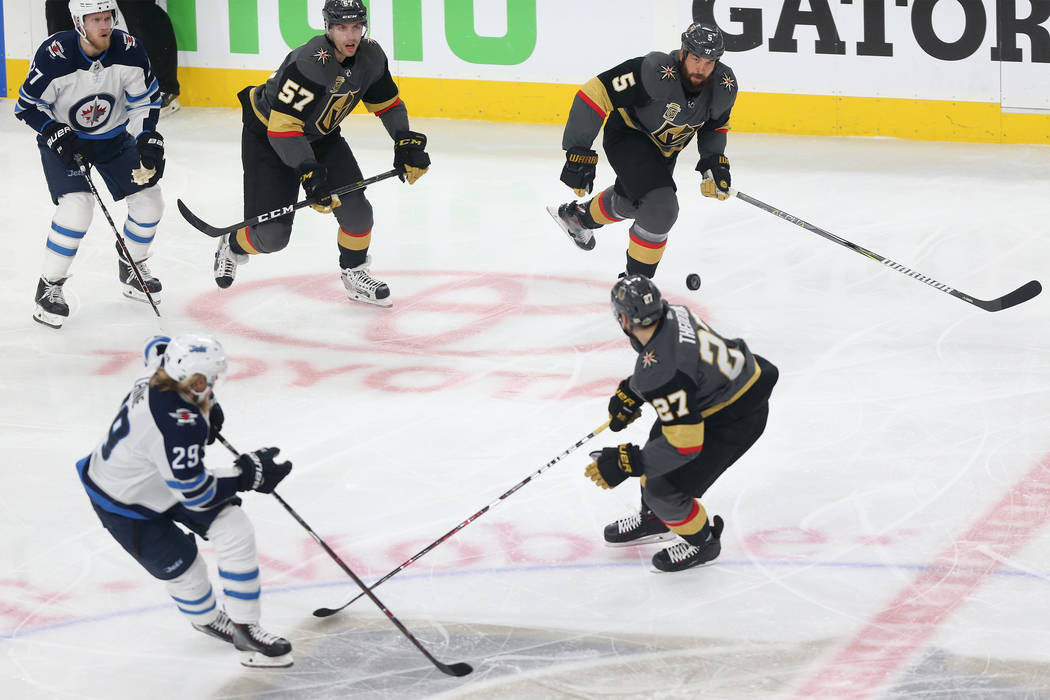 Vegas Golden Knights left wing David Perron (57), defenseman Deryk Engelland (5) and defenseman Shea Theodore (27) go for the puck against Winnipeg Jets left wing Nikolaj Ehlers (27) and right win ...