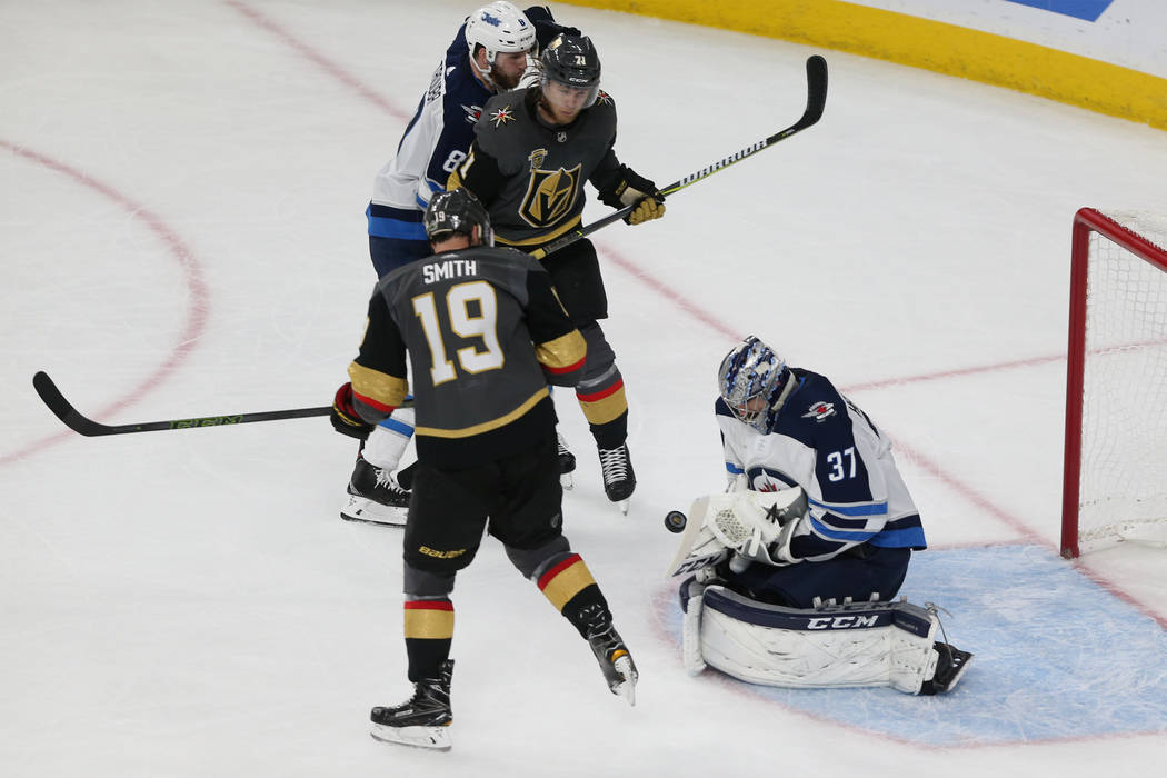 Winnipeg Jets goaltender Connor Hellebuyck (37) defends against Vegas Golden Knights right wing Reilly Smith (19) and center William Karlsson (71) during the second period in Game 4 of the Western ...