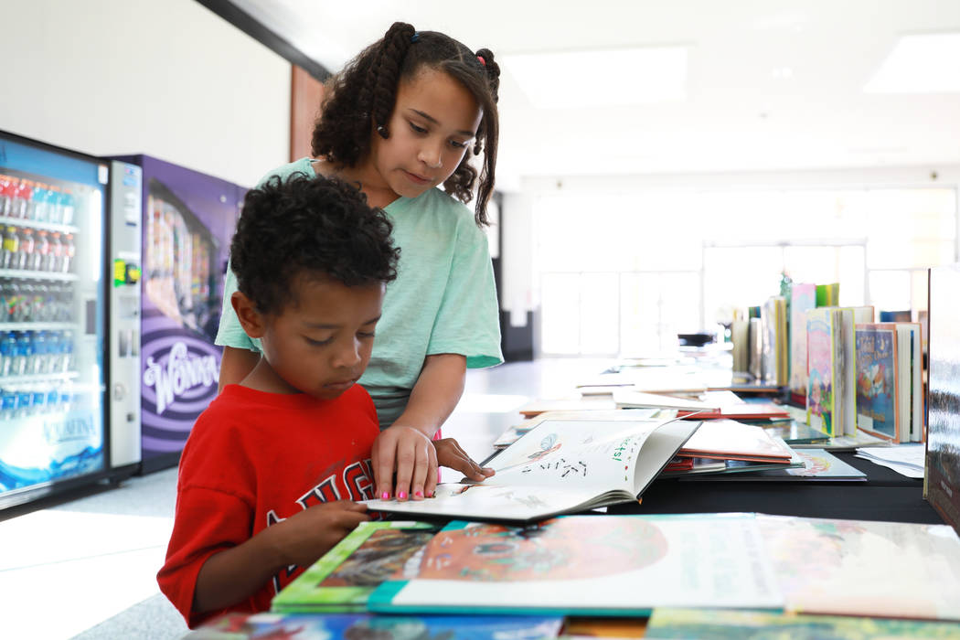 Lynnea Lamb, 11, helps her brother Deon, 5, read a book during the Reading Rangers Summer Reading Program at Boulevard Mall in Las Vegas on Saturday, May 19, 2018. Students were given the opportun ...