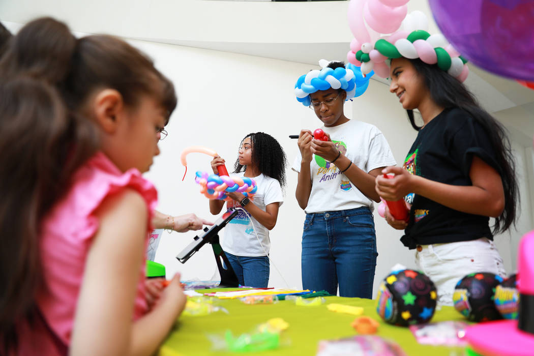 From left, Reyna Burch, 17, Mya Lofton, 19, and Susan Garcia, 19, make balloon animals for students during the Reading Rangers Summer Reading Program at Boulevard Mall in Las Vegas on Saturday, Ma ...