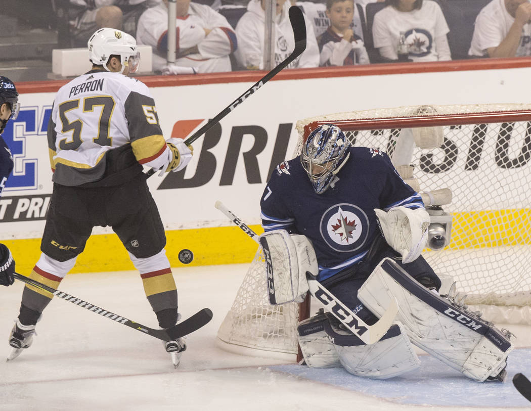 Jets goaltender Connor Hellebuyck (37) makes a save on Golden Knights left wing David Perron (57) in the first period during game five of the NHL Western Conference Finals on Sunday, May 20, 2018, ...