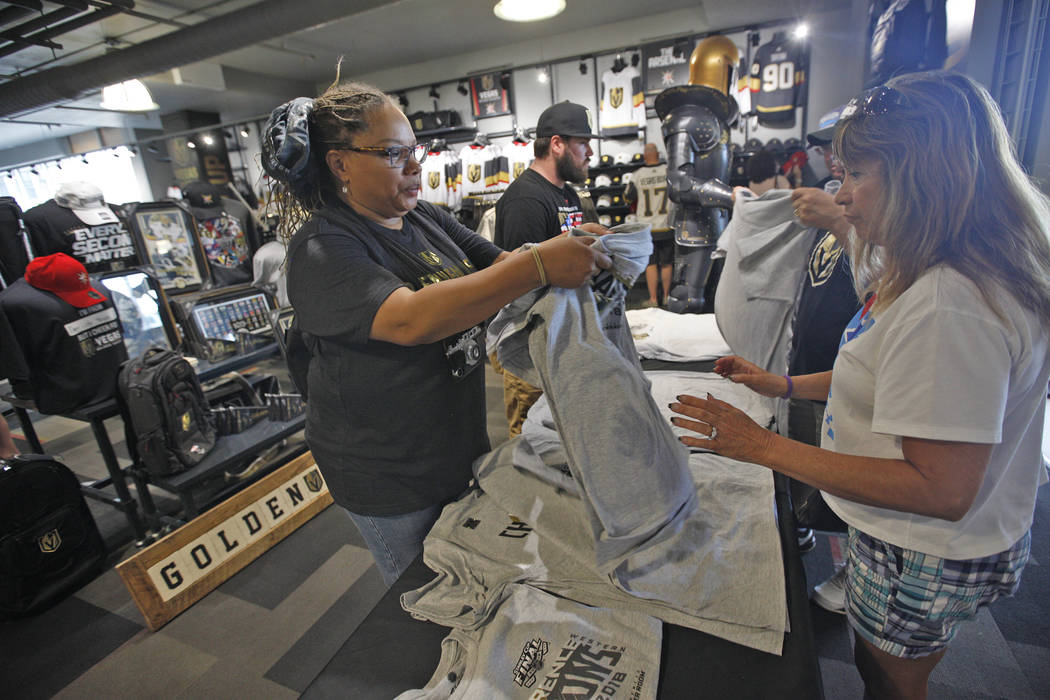 Kamala Frazho, left, gives a Golden Knights western conference championship shirt to Beverly Marques at the Arsenal retail store at the City National Arena in Las Vegas, Sunday, May 20, 2018. Rach ...