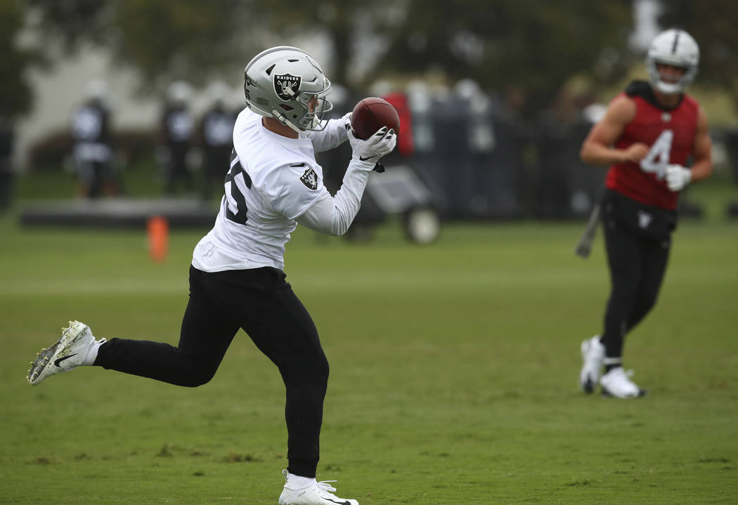 Oakland Raiders' Ryan Switzer, left, makes a catch on a pass from Derek Carr (4) during NFL football practice on Tuesday, May 22, 2018, at the team's training facility in Alameda, Calif. (AP Photo ...
