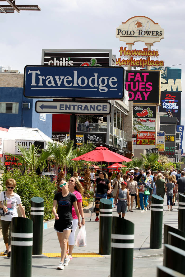 People walk on the Strip near Harmon Avenue past a 16-acre piece of property that is for sale Tuesday, May 22, 2018. K.M. Cannon Las Vegas Review-Journal @KMCannonPhoto