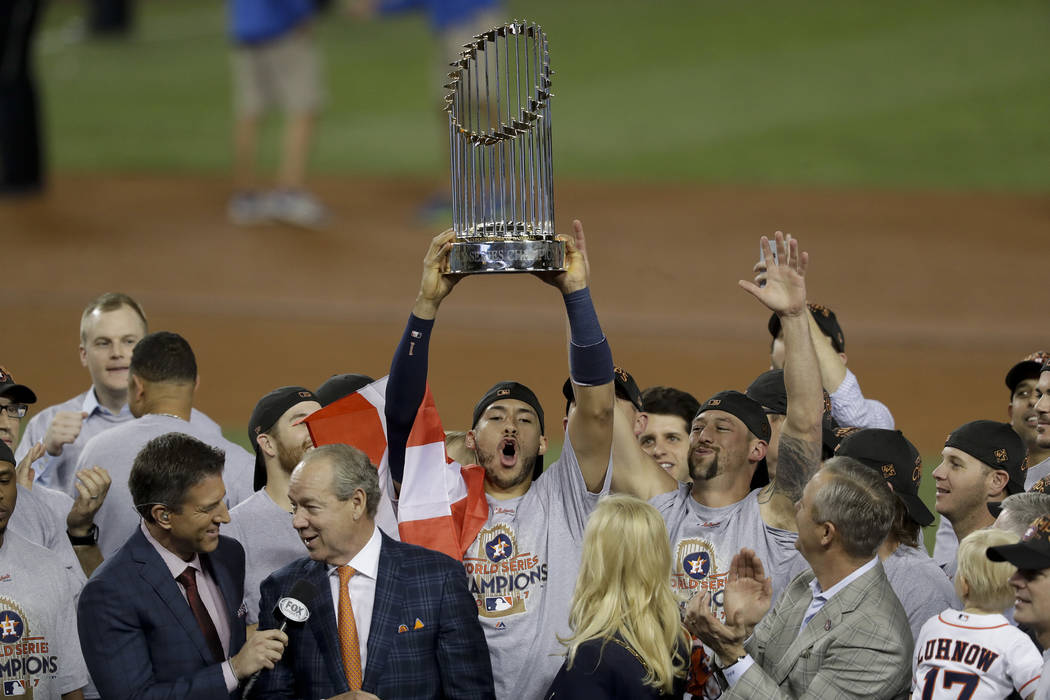 The Houston Astros' Carlos Correa celebrates with the trophy after their win against the Los Angeles Dodgers in Game 7 of baseball's World Series Wednesday, Nov. 1, 2017, in Los Angeles. The Astro ...