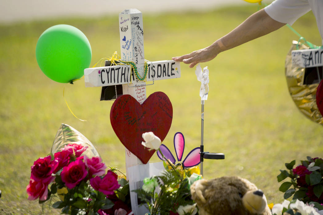 A woman gestures toward a cross honoring Santa Fe High School substitute teacher Cynthia Tisdale Tuesday, May 22, 2018, who was killed during a shooting at the school on Friday, in Santa Fe, Texas ...